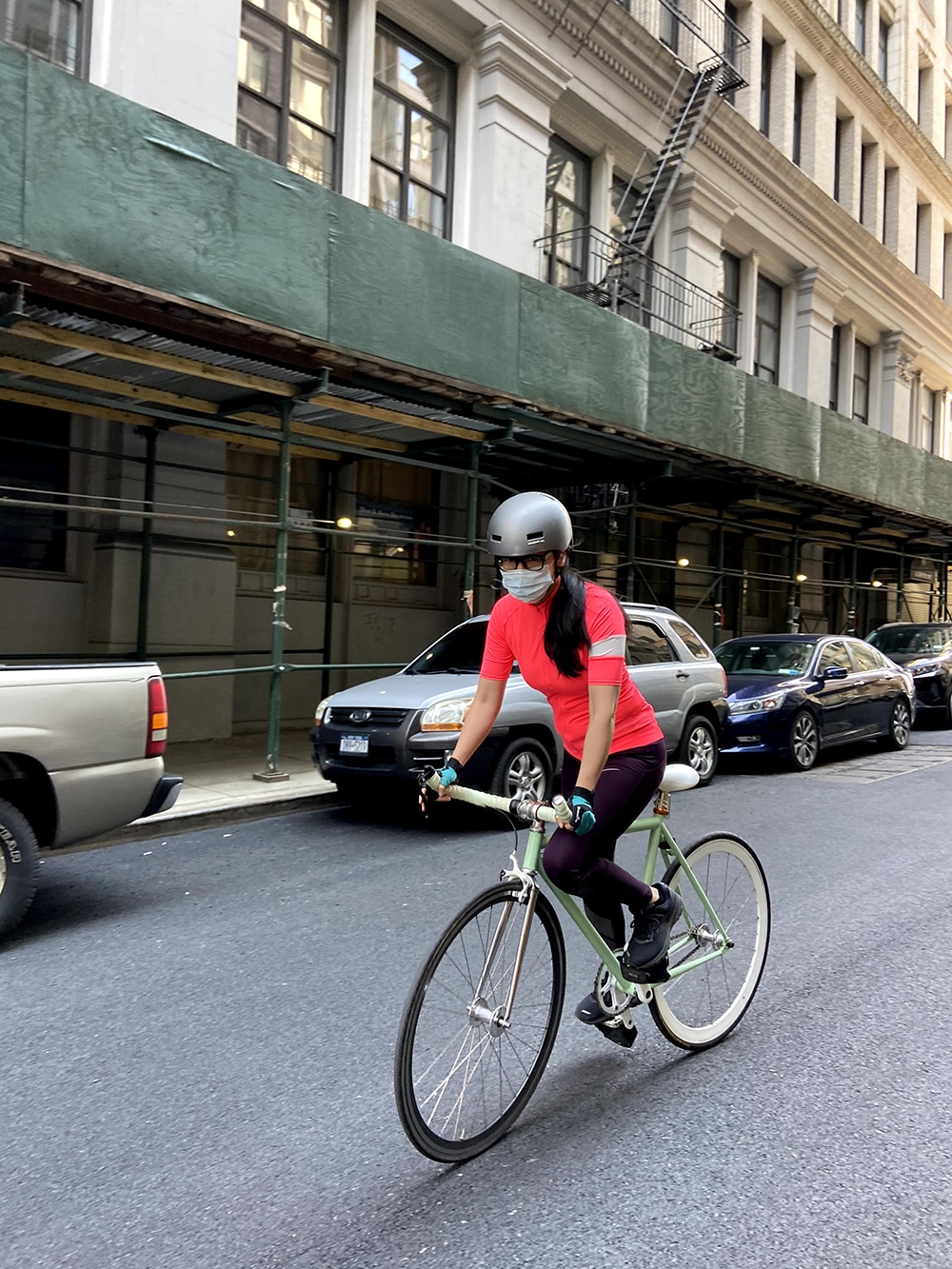 Me on my bike, 2021. I'm wearing a helmet and a surgical mask, a pink bike jersey, and stretchy pants.