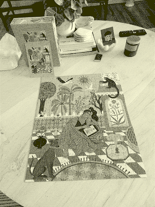 dithered image of a completed jigsaw puzzle on a coffee table with other knick-knacks strewn about