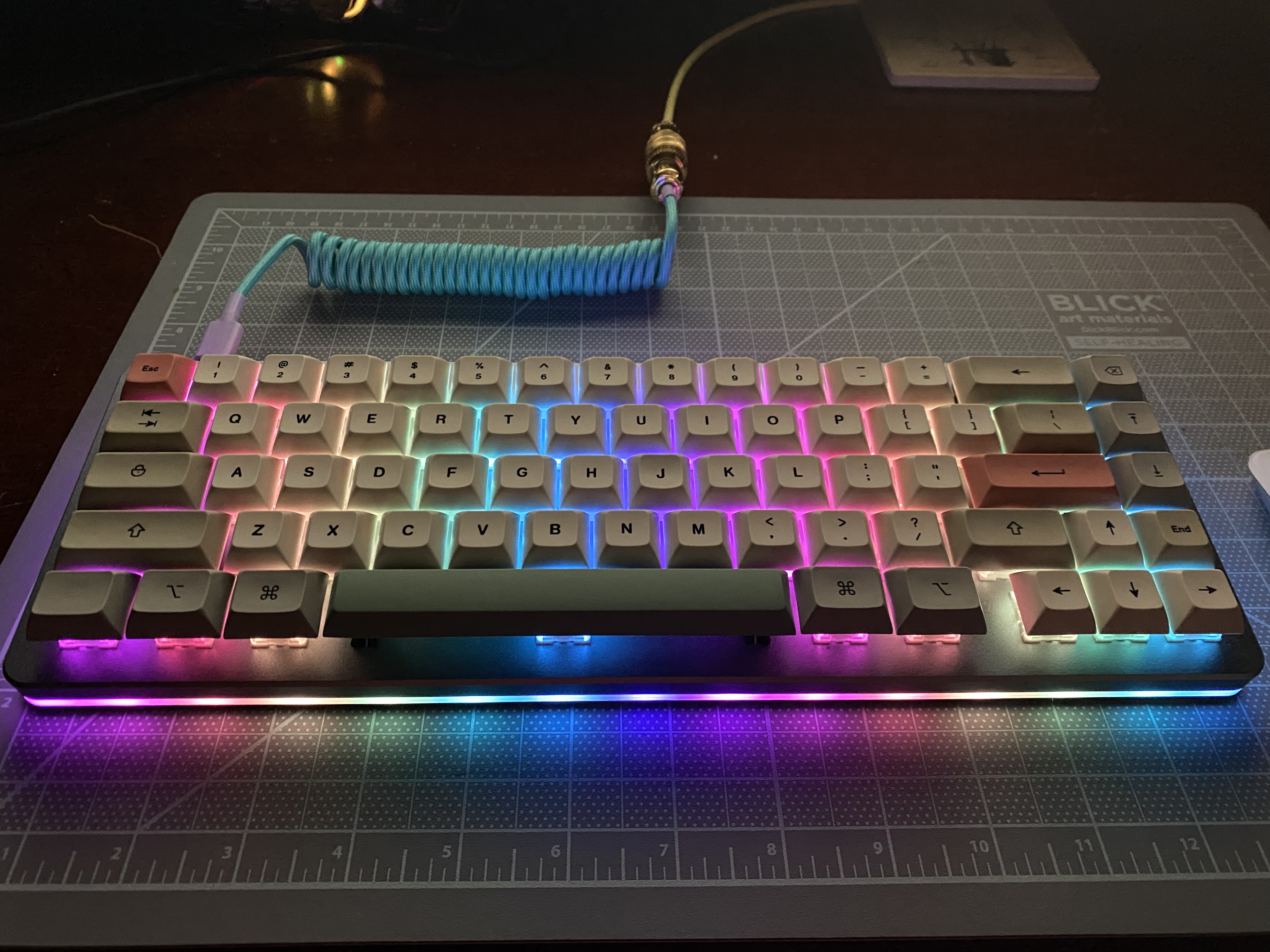 Closeup of a mechanical keyboard with multicolor LED lights and a cute colorful coiled aviator USB cable